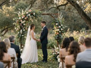 Cerimônia de casamento ao ar livre com arco floral orgânico de flores silvestres