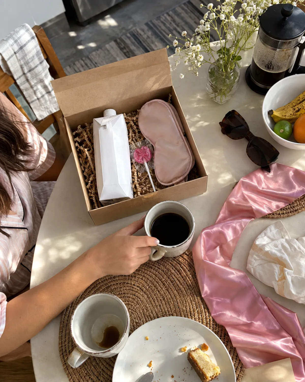 Mesa de café da manhã com kit ressaca em caixa kraft, máscara de dormir e xícara de café